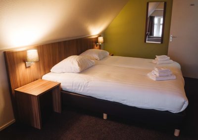 Tweepersoonskamer met 2 losse bedden zicht vanaf raam - Hotel Eckhardt Uithuizen